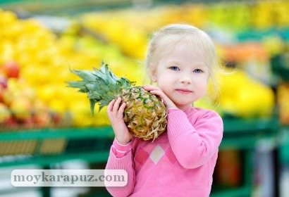 Девочка держит в руках экзотический фрукт