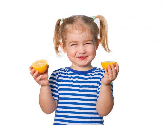 Девочка пробует лимон