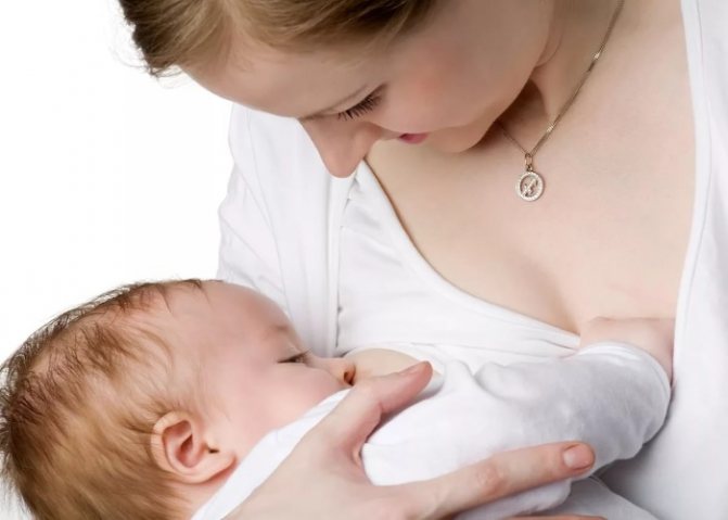 Молодая мама кормит ребенка грудью